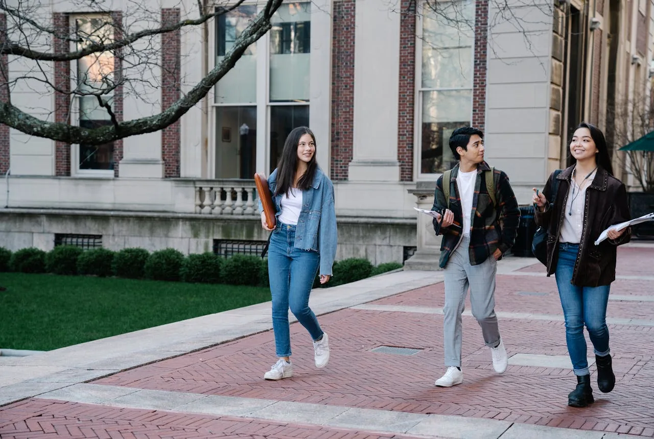 University students walking together across a campus courtyard between lectures.