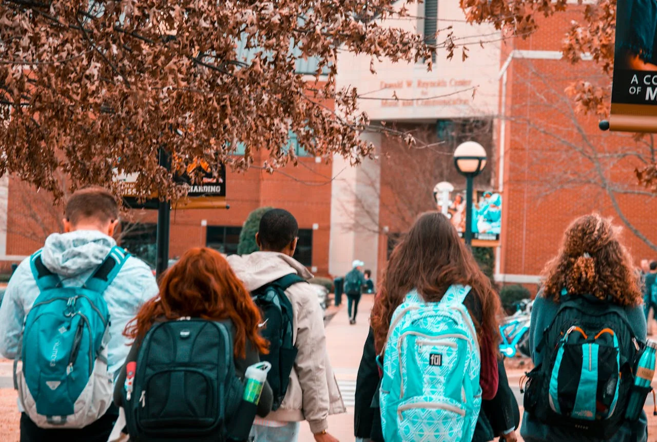 A group of university students socialising outdoors on campus.